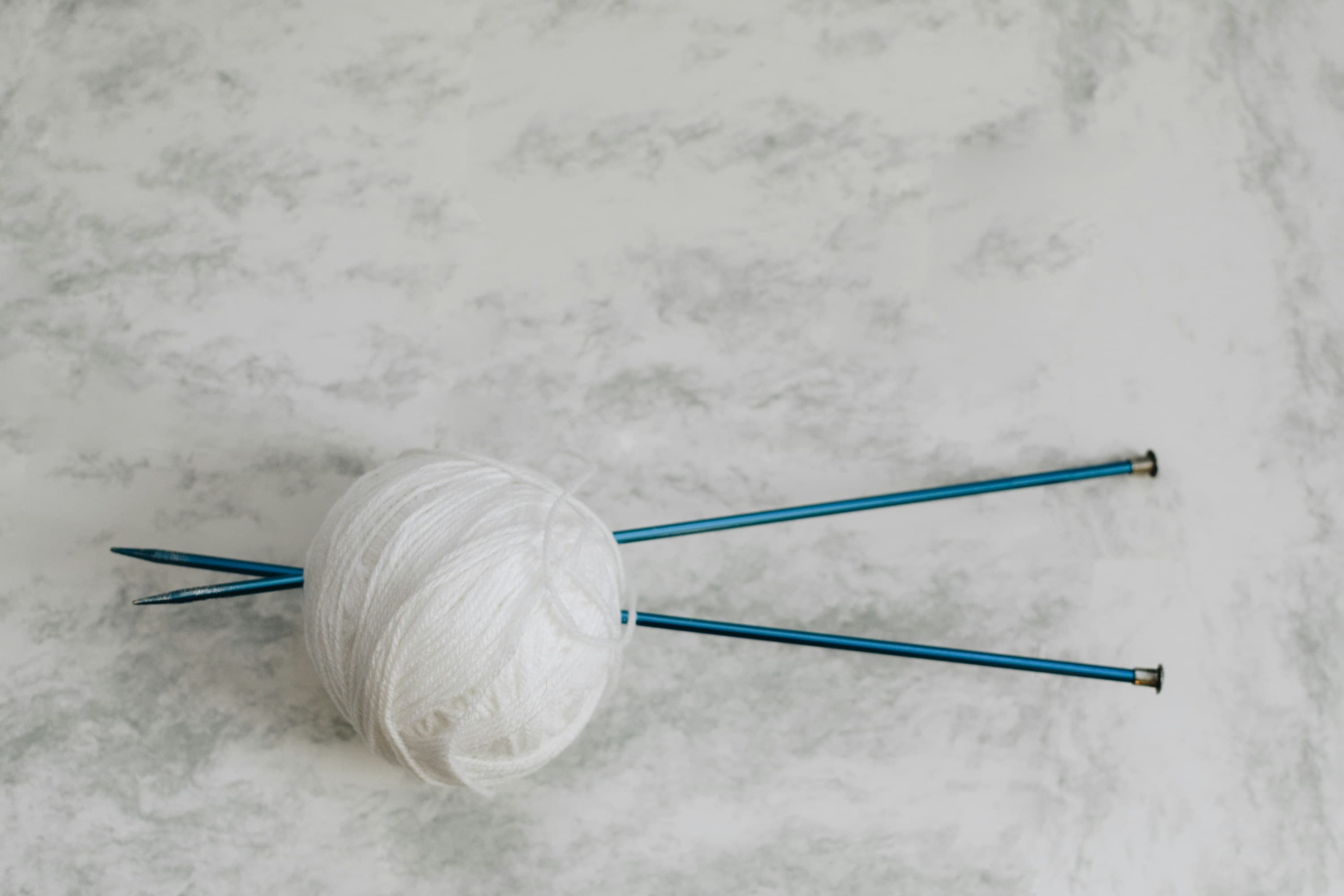 Ball of yarn with knitting needles.