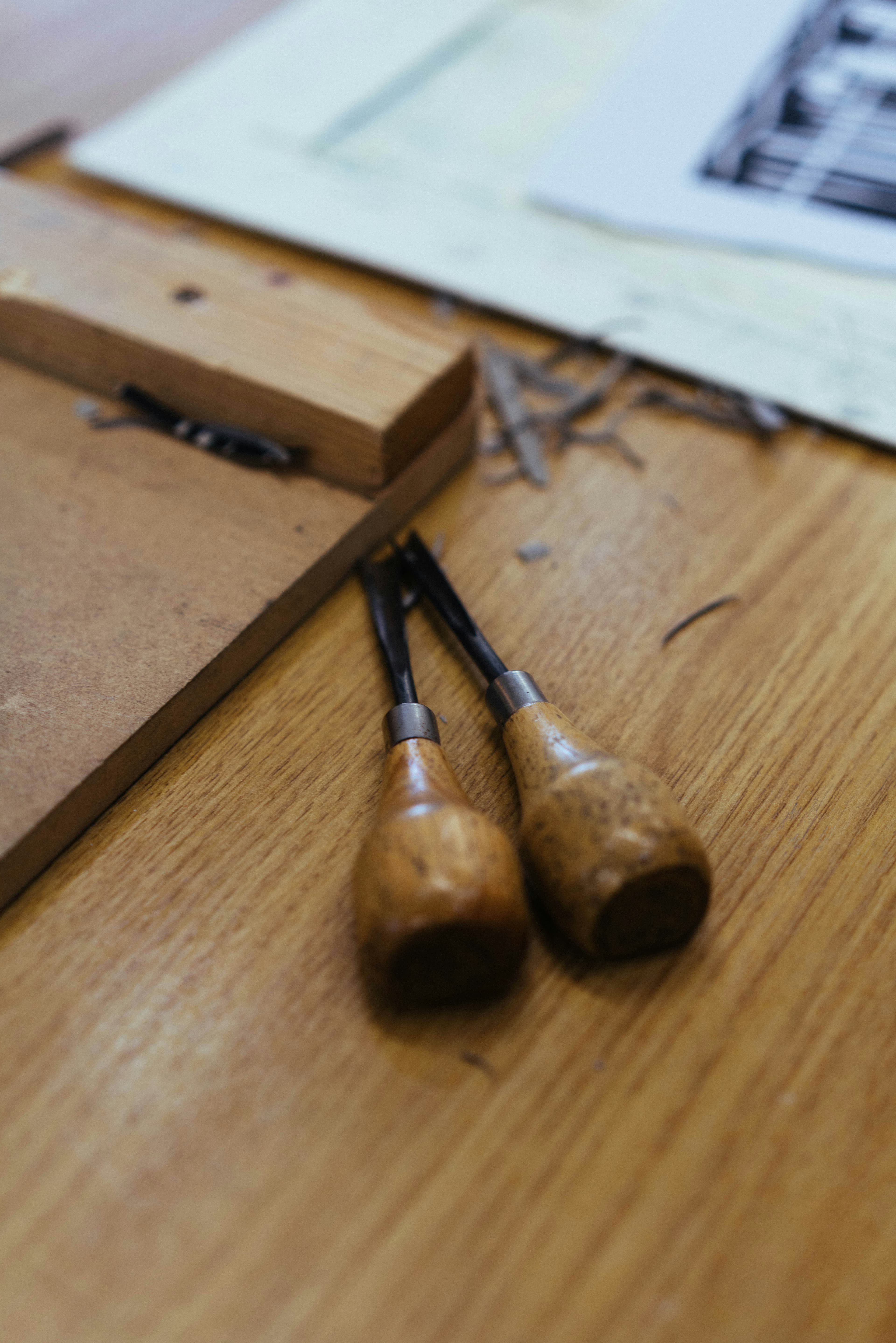 Wood carving tools laid out on a timber workbench.