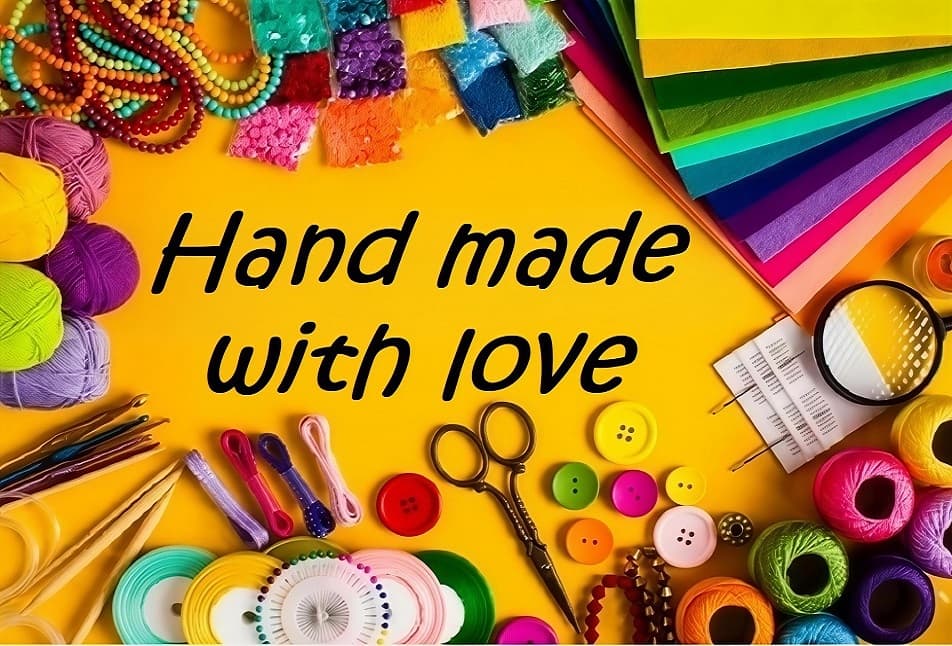 A riot of colourful yarn, buttons, thread and craft supplies arranged around the phrase 'Hand made with love'.